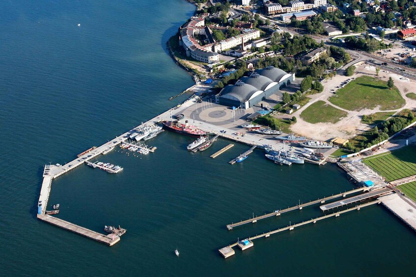 An aerial view of a harbor with boats, a large stadium, and surrounding buildings. 5
