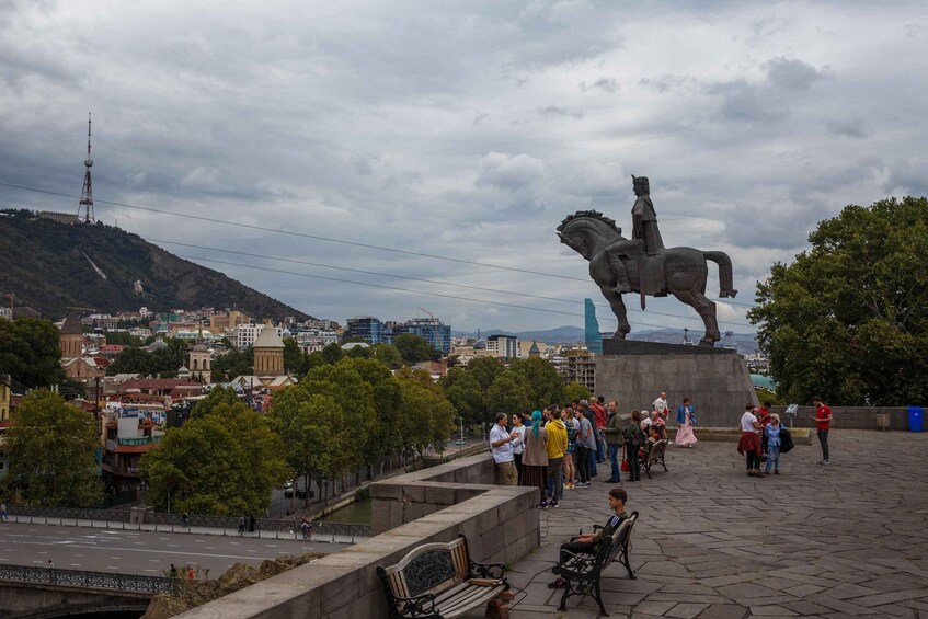 A statue of a man on horseback, a river, and a cityscape in the background. 3