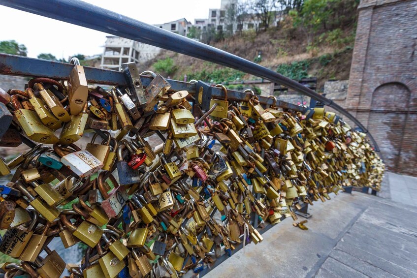 A bridge with numerous padlocks attached to its railing. 5