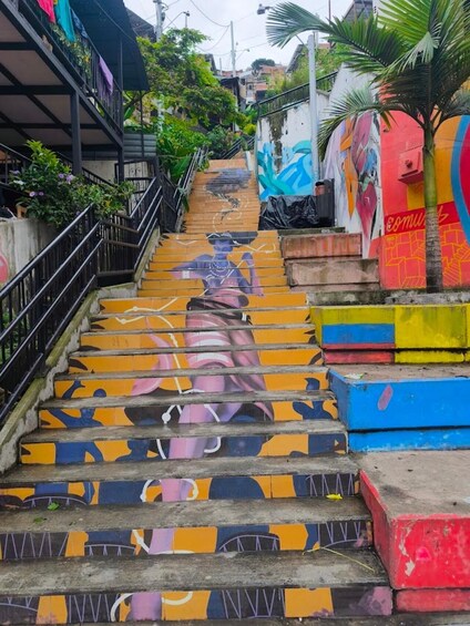 A staircase with colorful murals and a palm tree. 5