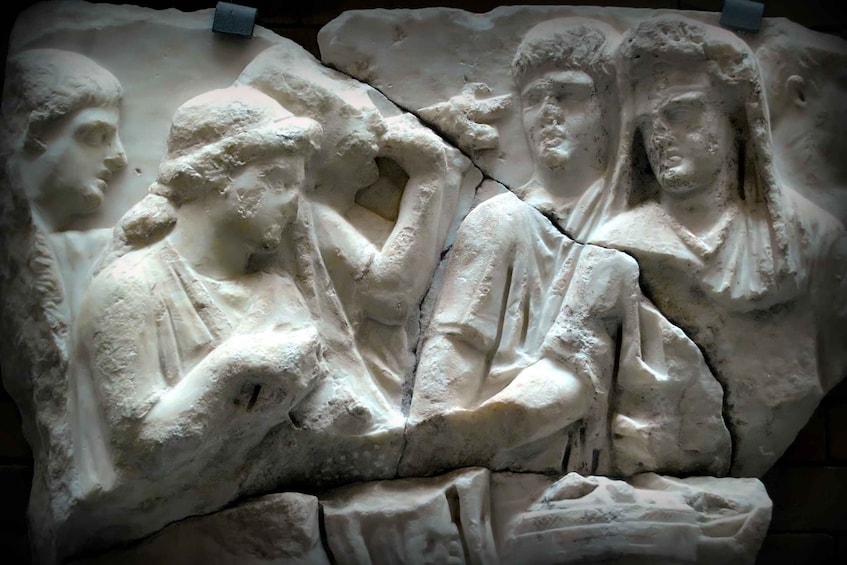 A marble relief sculpture with figures in draped garments, depicting a historical or mythological scene. 5