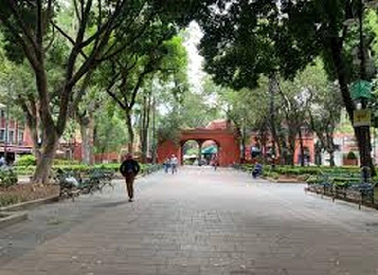 A tree-lined pathway with a red archway in the distance. 2