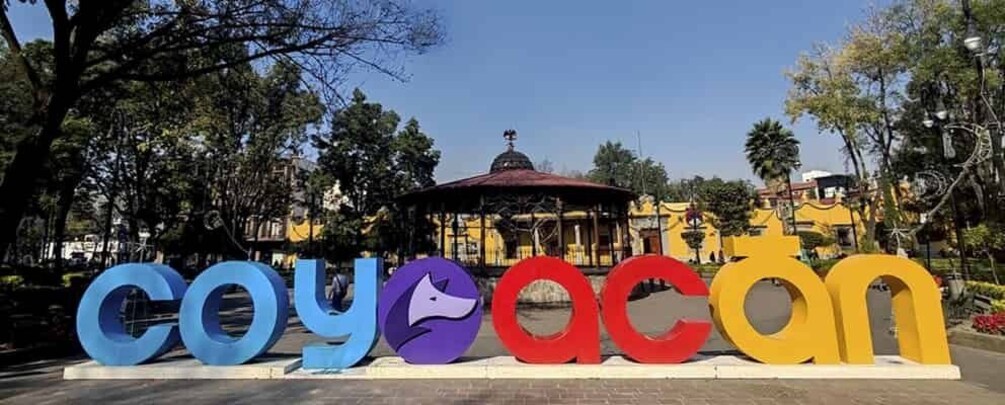 Large colorful letters spelling 'Coyocan' with a gazebo in the background. 1