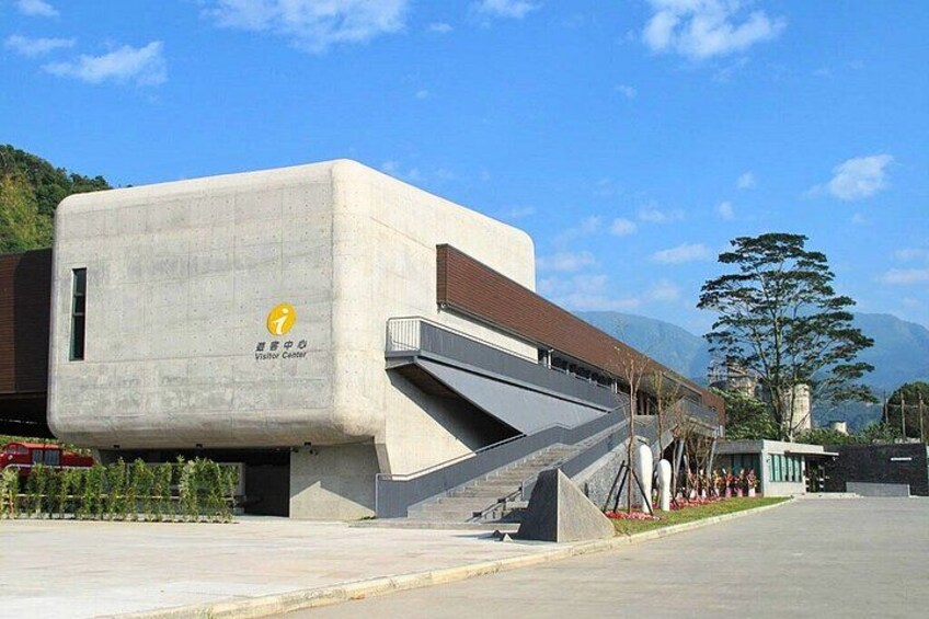 Un edificio moderno con un diseño arquitectónico único, un letrero de centro de visitantes y una escalera que conduce hacia él. 3