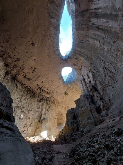 A cave with natural rock formations and a narrow passageway. 5