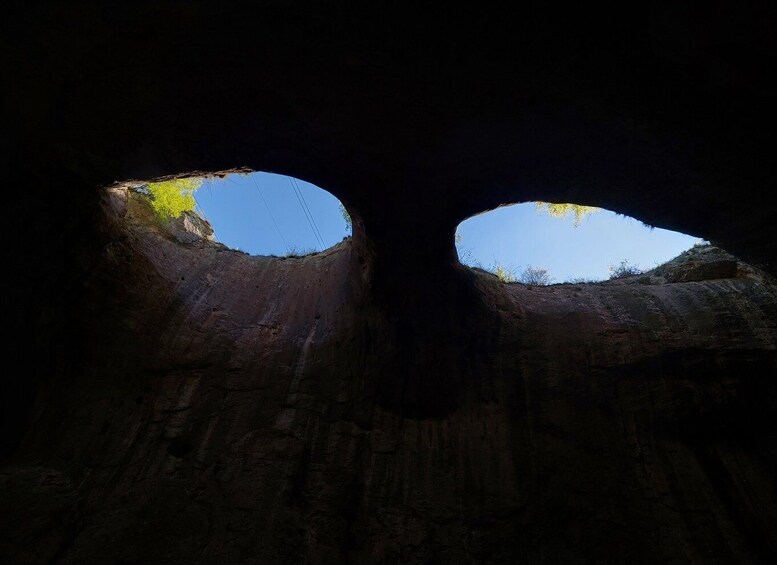 An underground passage with two circular openings leading to the sky. 1