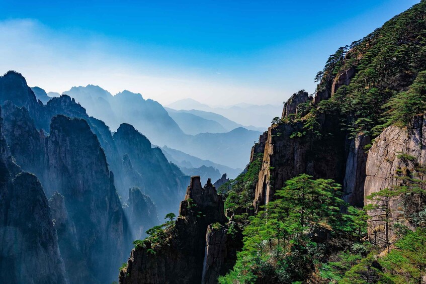 A mountainous landscape with steep cliffs and dense greenery. 4