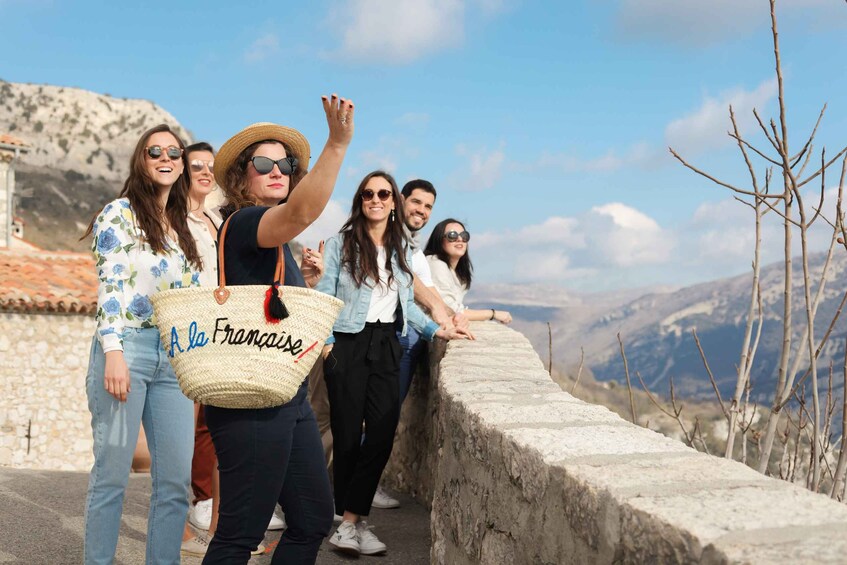 A group of people on a stone wall overlooking a mountainous landscape. 5