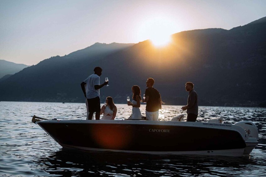 A group of people on a boat with a mountainous backdrop and the sun setting. 4