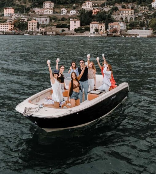 A group of people on a boat with a coastal town in the background. 1