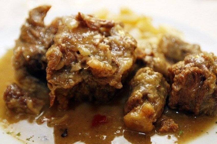 Eine Nahaufnahme eines Gerichts mit Fleisch und Soße. 2