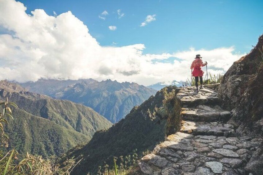 A hiker on a stone path with mountains in the background. 4