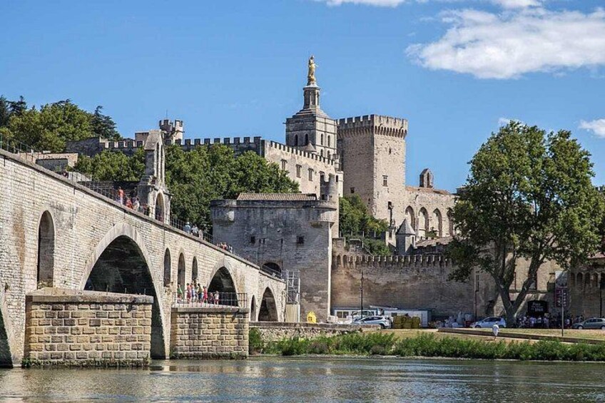 Een stenen brug met bogen, een kasteel met een toren en een rivier. 5