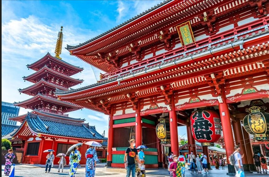 Perinteinen japanilainen temppeli, jossa on punainen ja kultainen arkkitehtuuri, mukaan lukien huomiota herättävä pagodi ja koristeelliset pylväät. 1