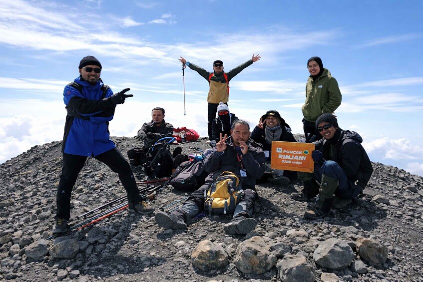 A group of people on a rocky mountain peak with a clear sky. 4