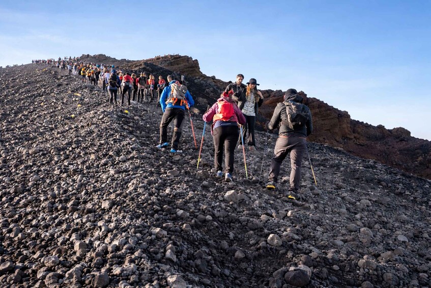 A group of hikers ascending a rocky slope. 3