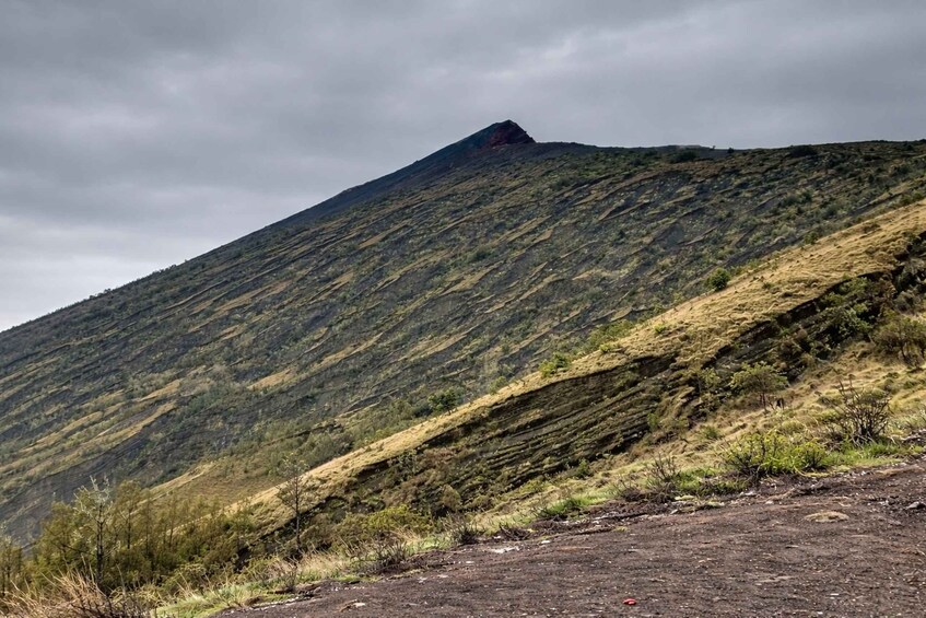 A rugged mountain with a prominent peak and a dirt path leading up. 2