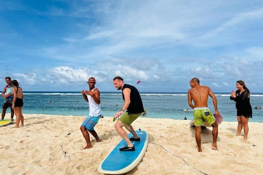 Des personnes sur une plage, avec des planches de surf, des vagues et un ciel dégagé. 1