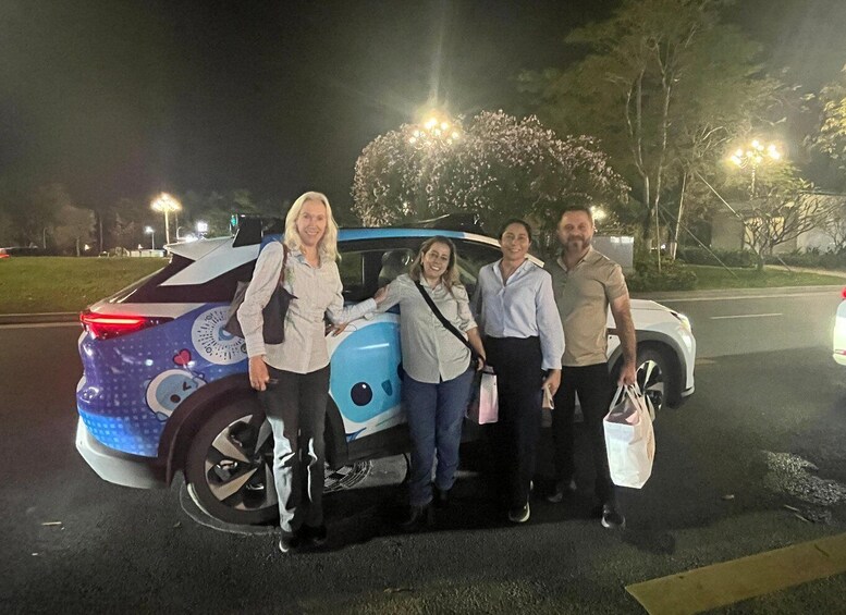 A group of people standing next to a blue and white vehicle with a cartoon character on the side. 2