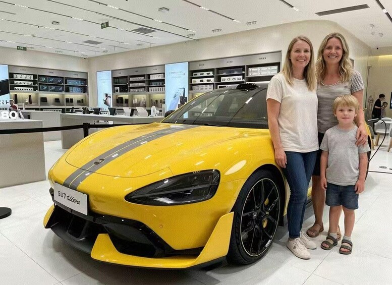 A yellow sports car with a black stripe, a woman, a child, and a store interior with shelves and products. 5