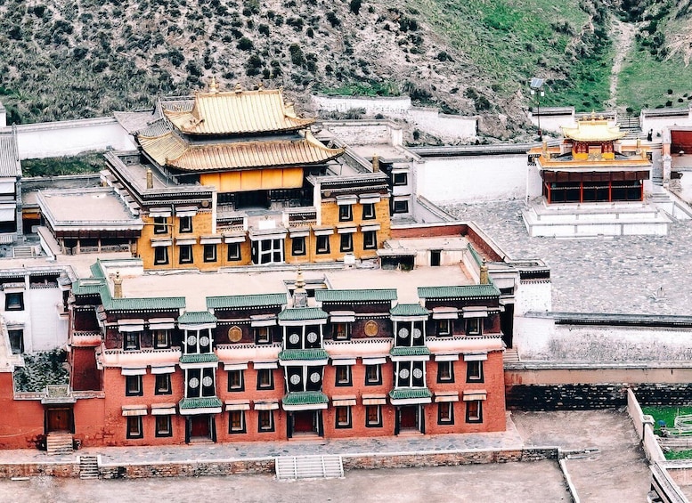 A traditional Tibetan monastery with multi-tiered buildings and ornate roofs. 2