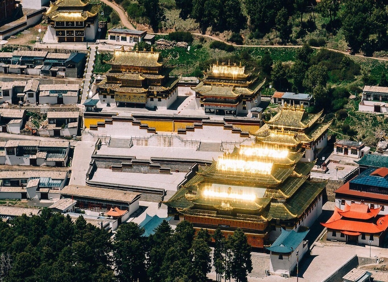 A traditional Chinese temple complex with golden roofs and white walls. 4