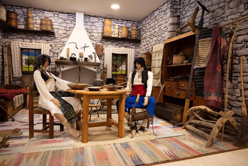 A rustic interior with stone walls, wooden furniture, and vintage kitchen tools. 3