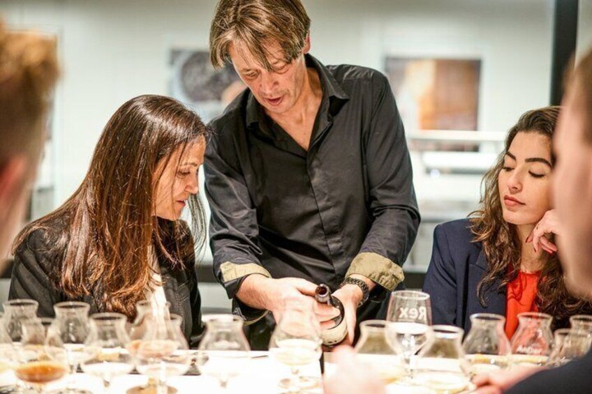 Un grupo de personas sentadas a una mesa con copas de vino. 3