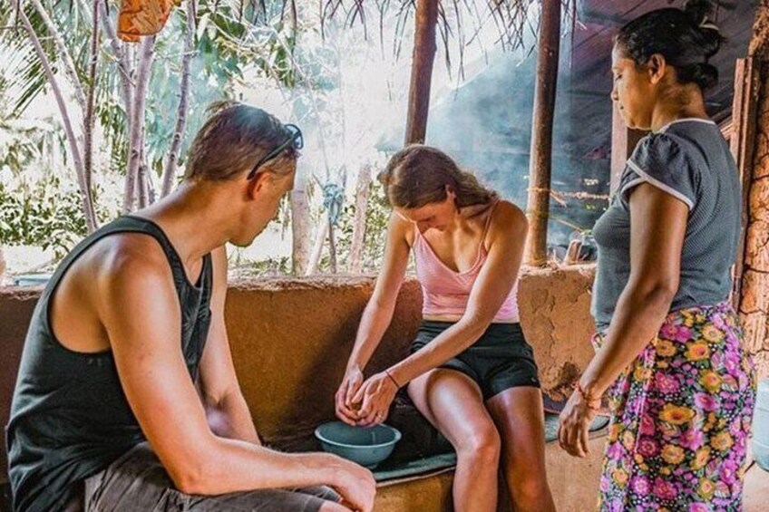Three people sitting and standing outdoors, with one person holding a bowl. 1