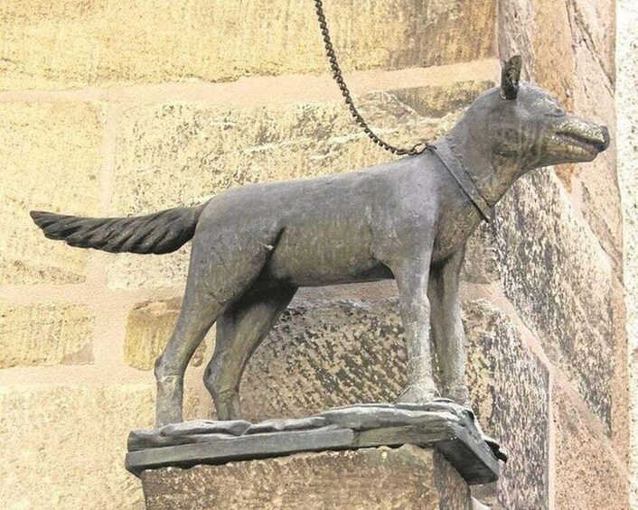A stone sculpture of a wolf mounted on a wall. 3