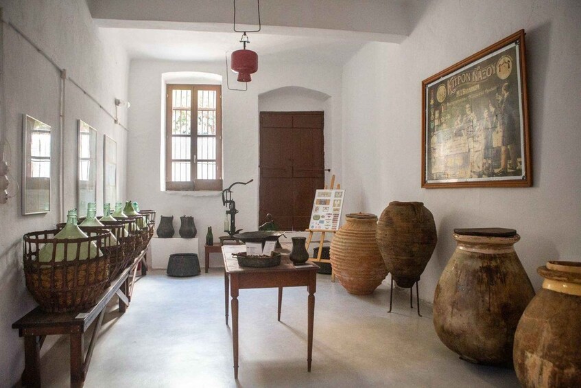 A museum interior with pottery, a framed historical painting, and a window with barred glass. 2