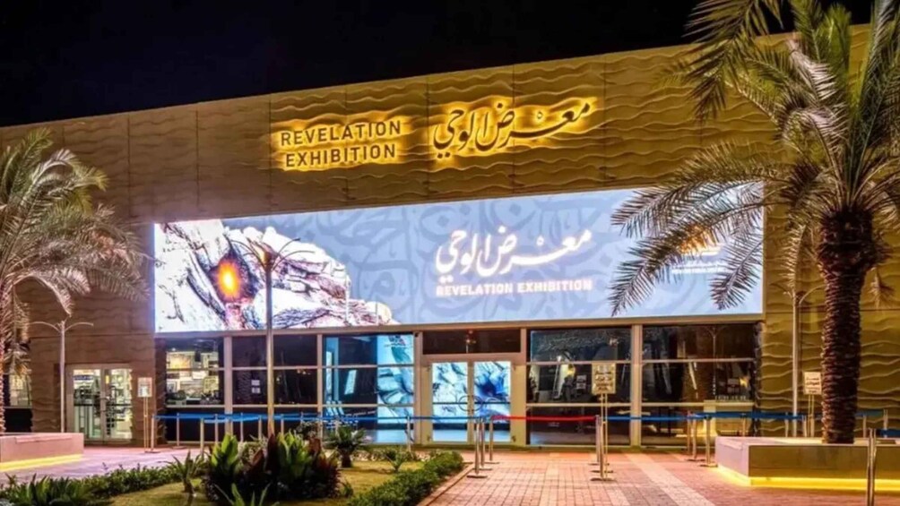 A building with 'Revelation Exhibition' signage and a large illuminated display. 3