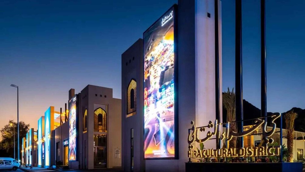 A building with illuminated signage and large digital displays. 3