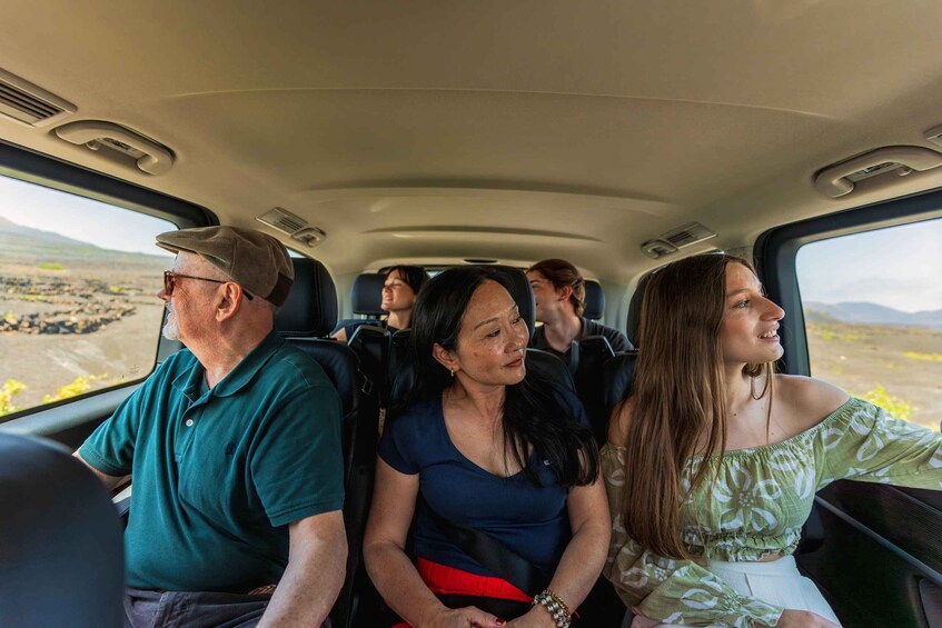 A vehicle interior with passengers seated. 4