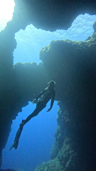 A diver swimming through a large underwater cave. 3