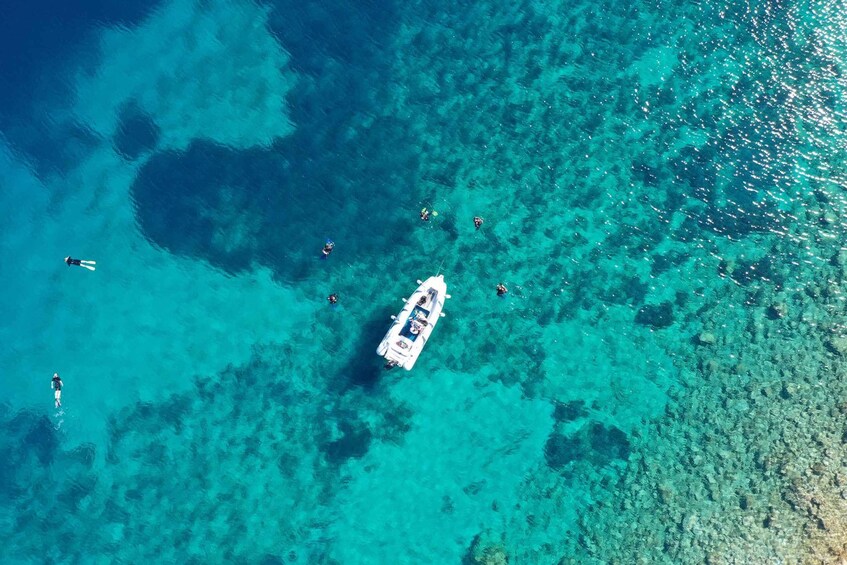 A boat with divers in clear turquoise waters. 1