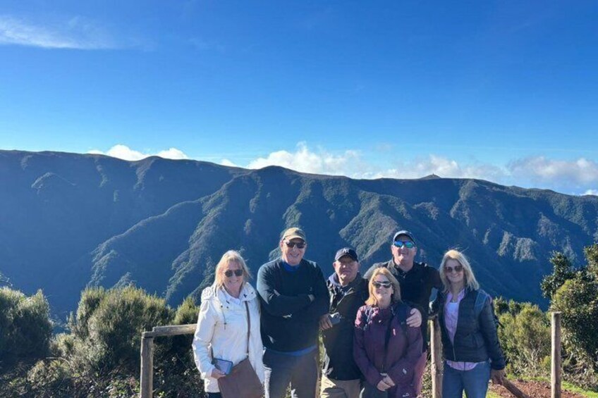 A group of people standing on a trail with a mountainous landscape in the background. 4