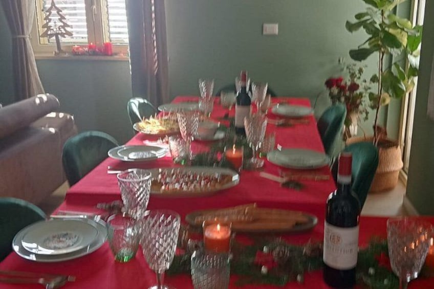 A dining table set for a meal with plates, glasses, and a bottle of wine. 4