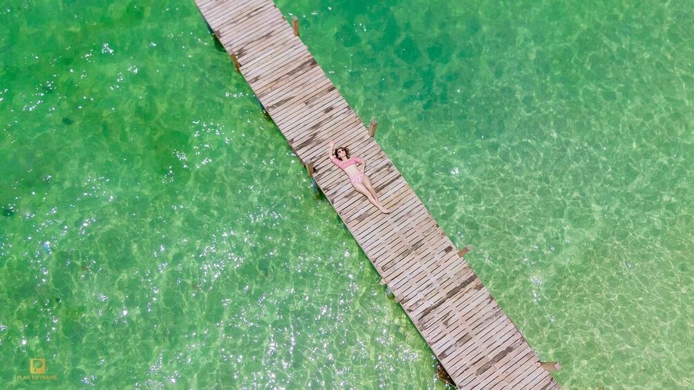 A wooden pier extending into clear turquoise water. 3