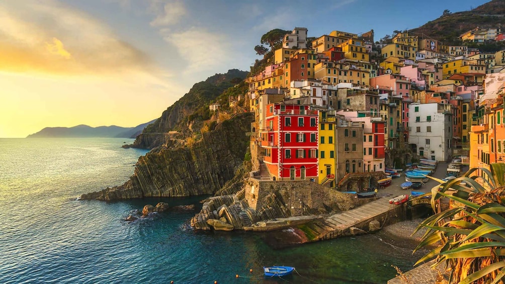 A coastal village with colorful buildings, a rocky shoreline, and boats. 1