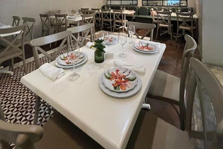 A restaurant interior with tables set for dining, chairs, and a patterned floor. 4