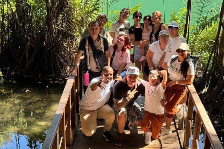 A group of people on a wooden bridge in a mangrove area. 1