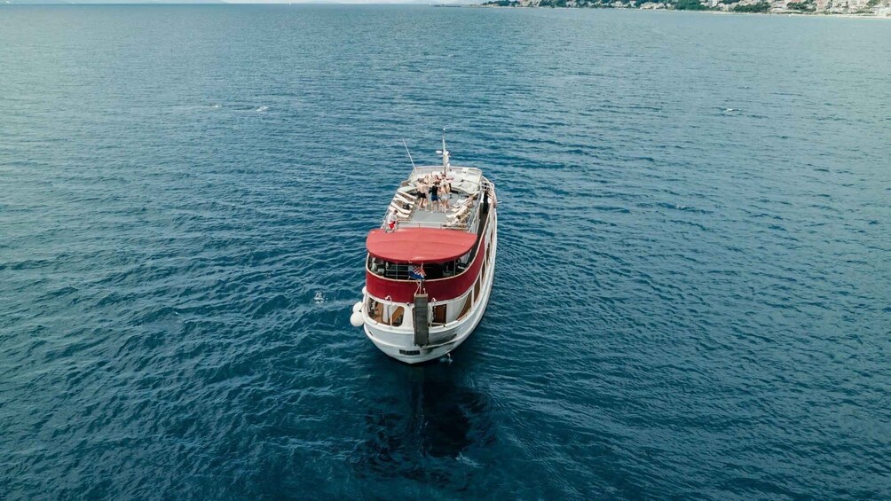 A red and white boat on calm blue water. 3