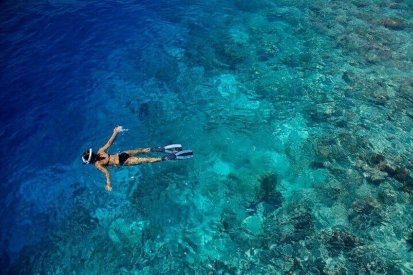 Une personne faisant de la plongée avec tuba dans une eau d’un bleu cristallin. 4