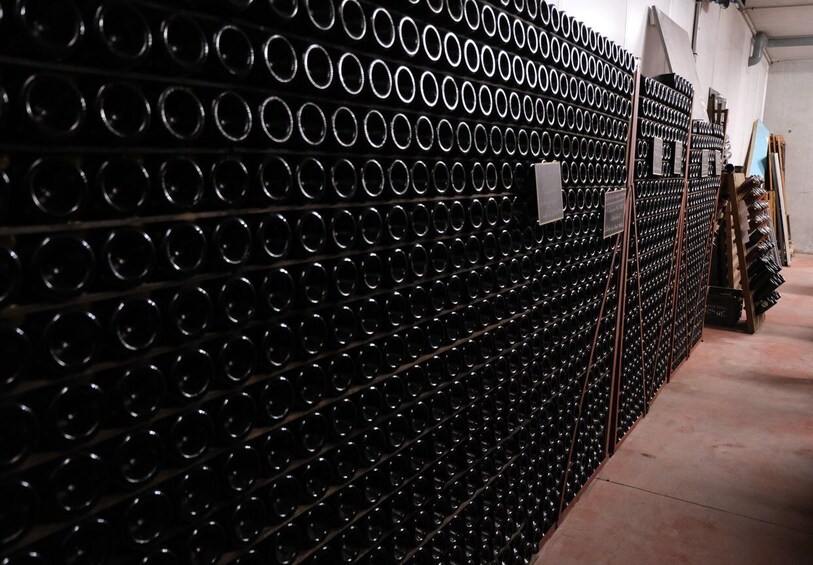 A storage area with rows of wine bottles on shelves. 5