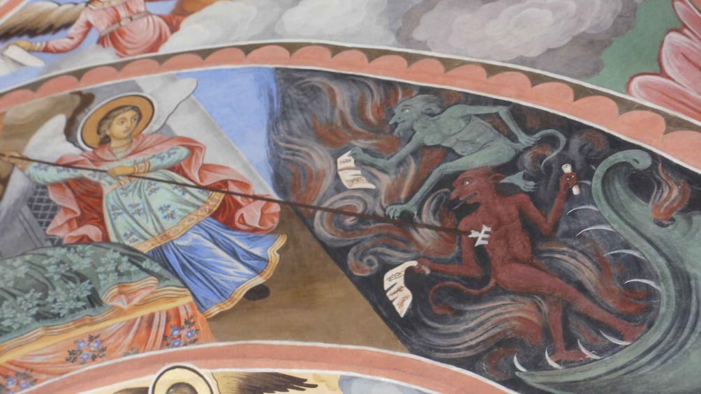 A religious mural with a figure of a saint, a dragon, and a serpent. 5