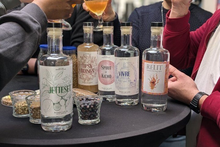 Een tafel met verschillende flessen sterke drank en kleine potjes kruiden. 1