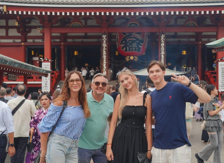 A group of people in front of a traditional Japanese building with a red torii gate. 4