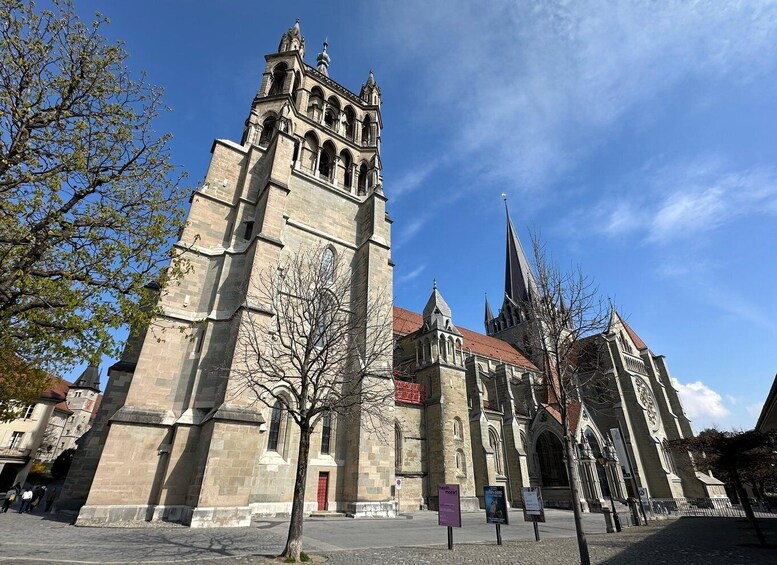 A historic church with a prominent tower and spire, surrounded by trees and a clear sky. 5