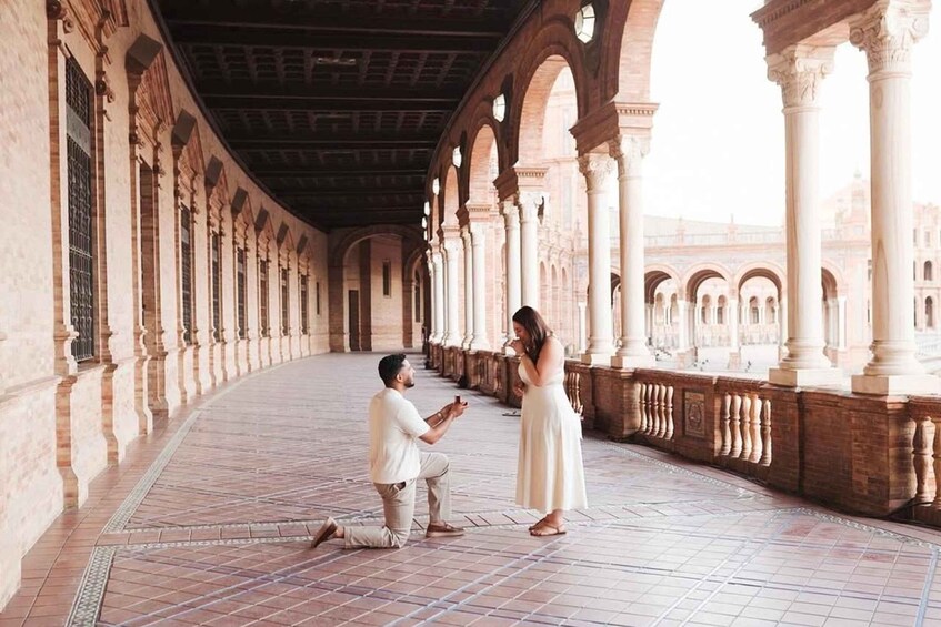 A man proposing to a woman in an architectural courtyard with arches and columns. 5